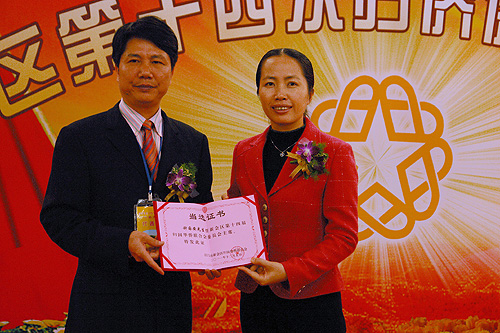 新會區(qū)委常委張蓮友（右）向新任區(qū)僑聯(lián)主席鐘國安（左）頒發(fā)當選證書