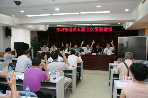 會(huì)上，市僑聯(lián)常委們舉手表決有關(guān)人事事項(xiàng)。李恩 攝