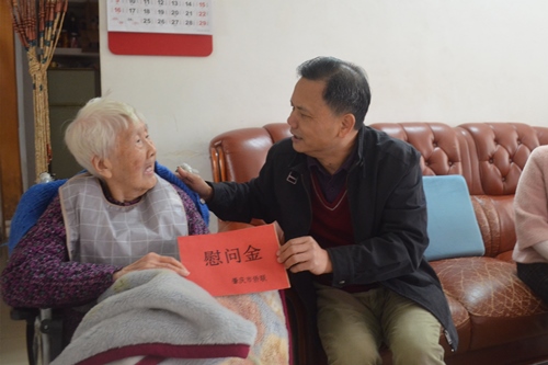 2市僑聯(lián)一級調(diào)研員黃志堅（右）向印尼歸僑郭惠英送上慰問金_副本.jpg